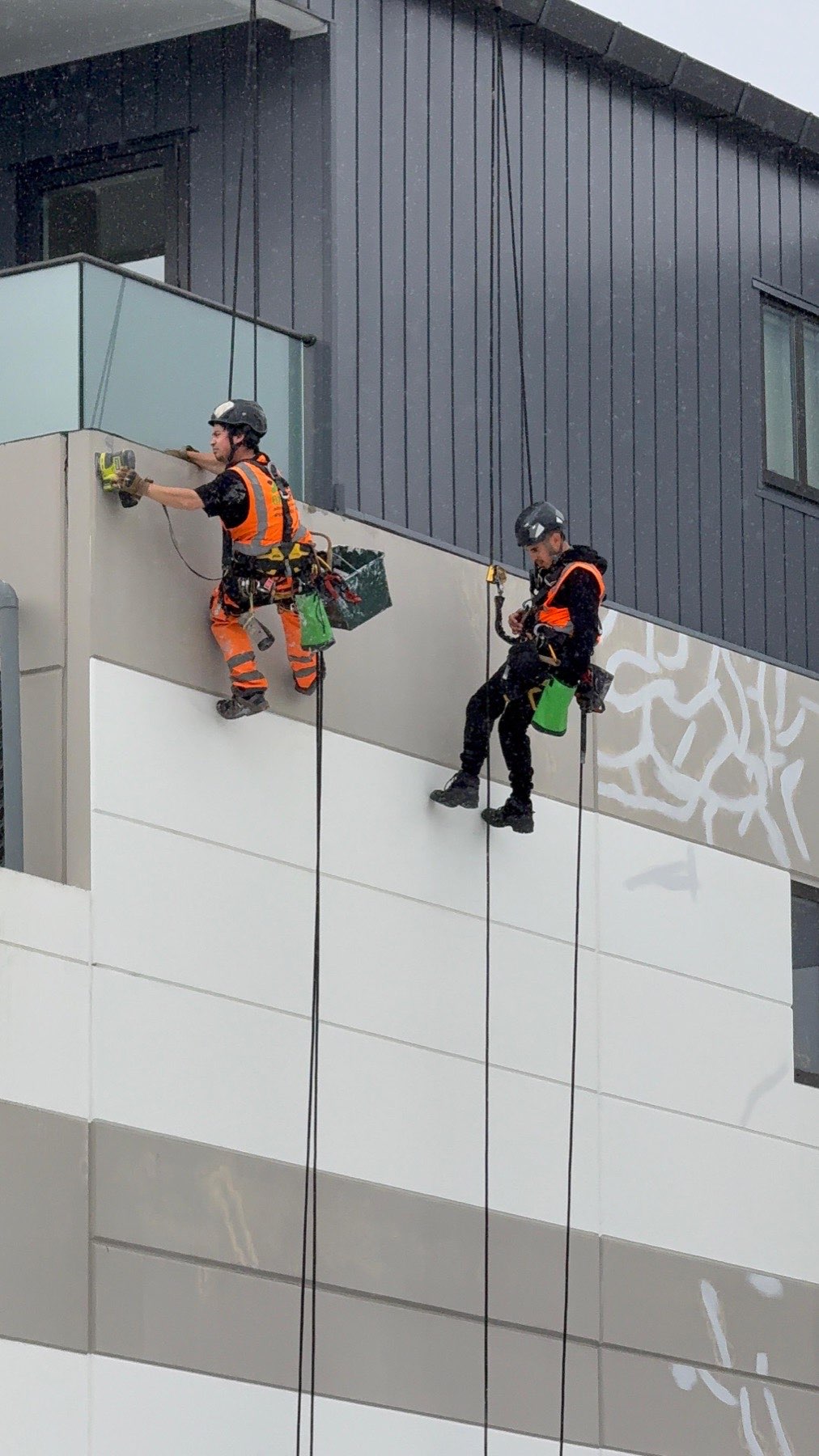 Two On Ropes technicians descending an apartment building elevation on twin ropes