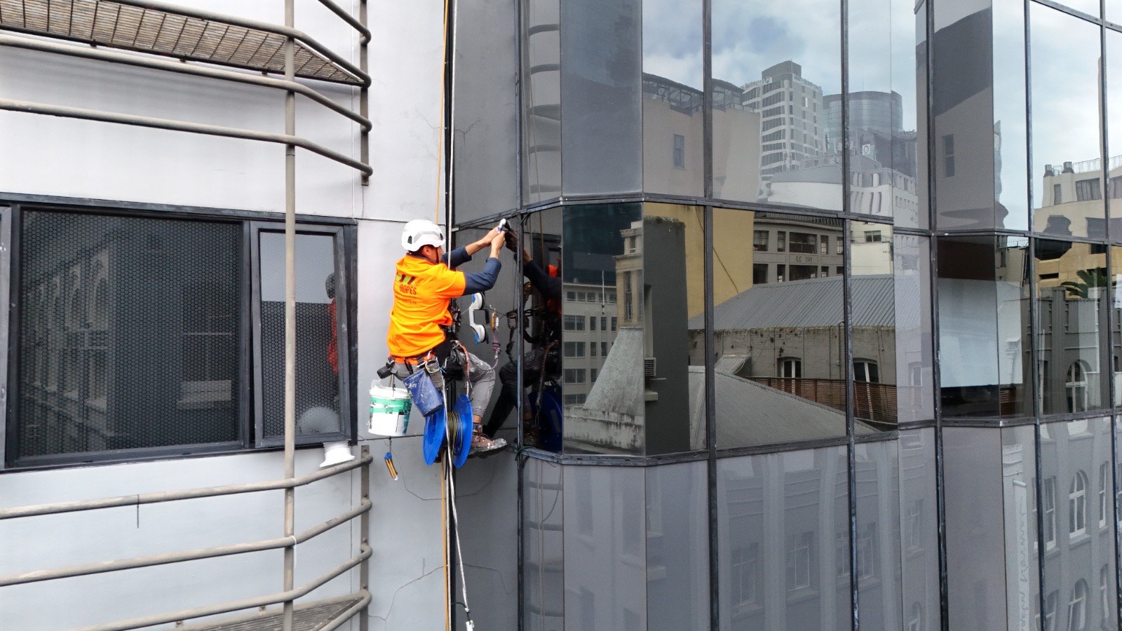 On Ropes technician resealing a glazing perimeter joint on a curtain wall from the rope