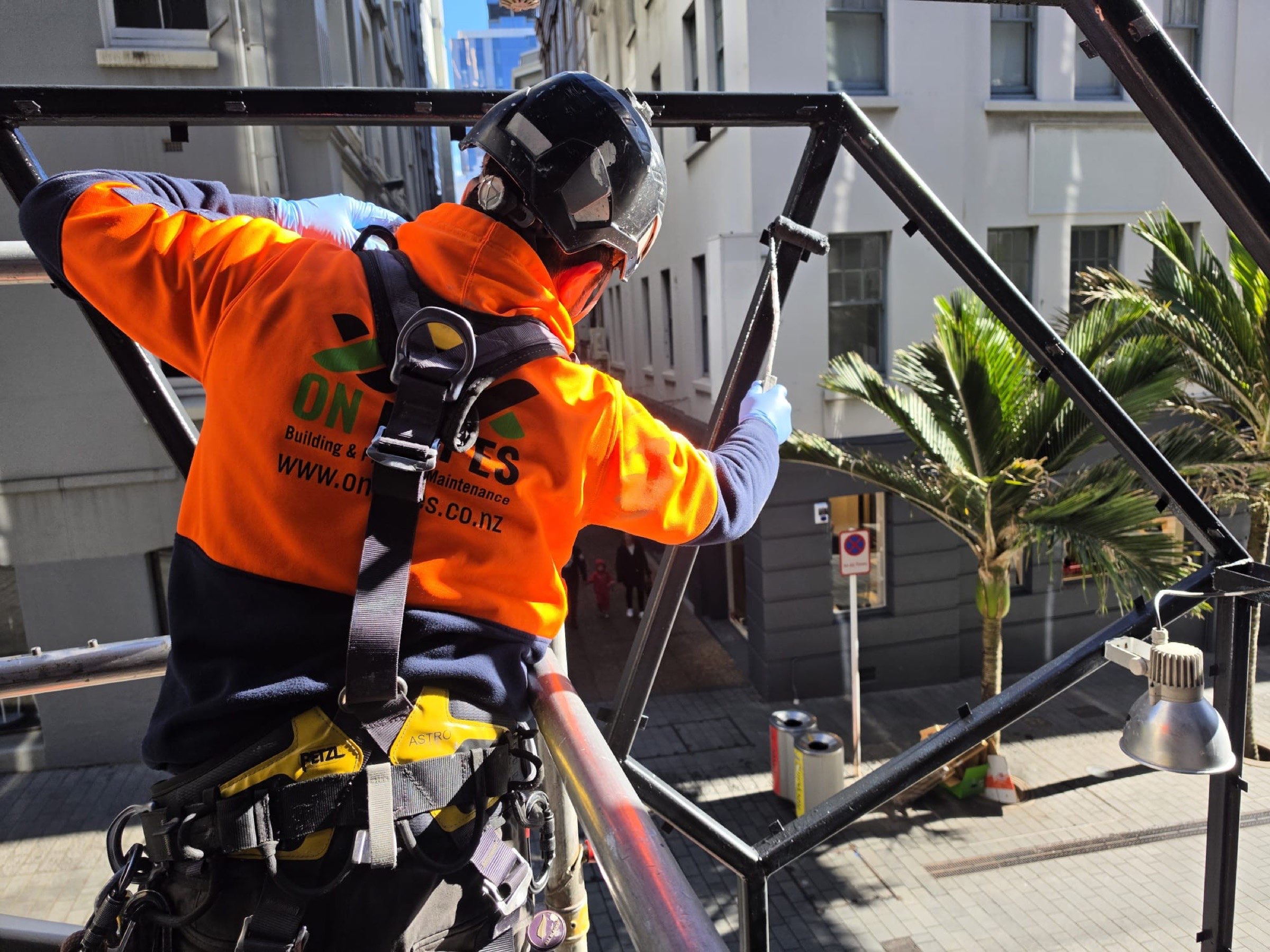 On Ropes technician in branded hi-vis working on an exterior steel frame